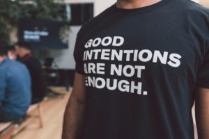 Torso of person wearing tshirt reading good intentions are not enough. 
